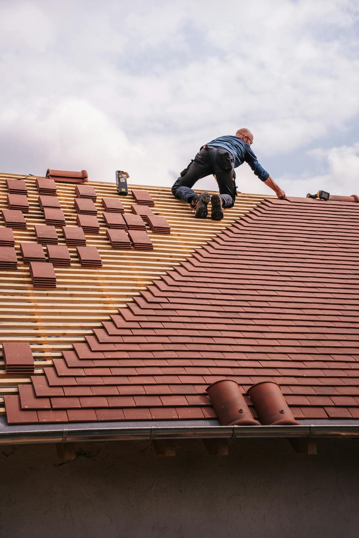 Dachdecker bei der Verlegung neuer Dachschindeln